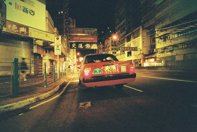 a red car parked in front of an alleyway