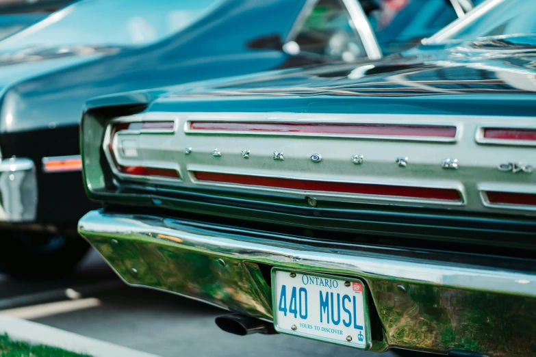 a vintage green car and another vintage one are parked next to each other