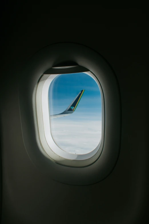 view out of an airplane window of clouds and the sky