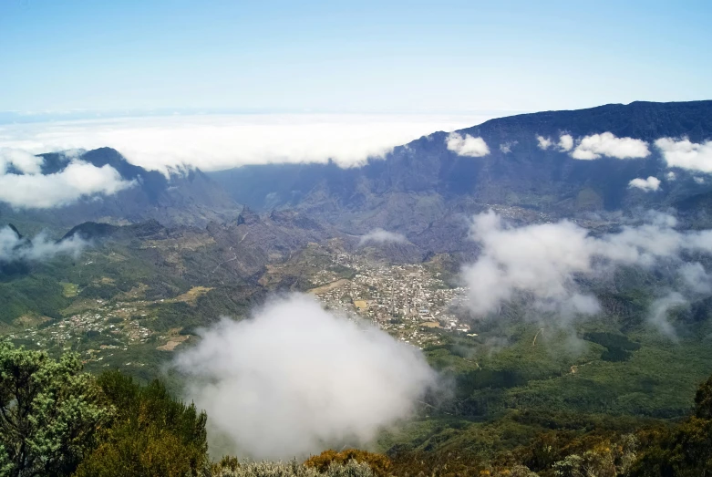 view of a city in the distance surrounded by fog and clouds