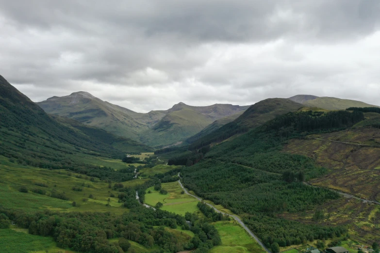 a valley and mountains, with many trees on the side