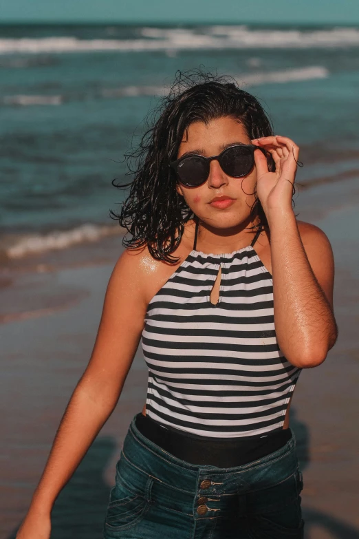 the girl in glasses stands on the beach