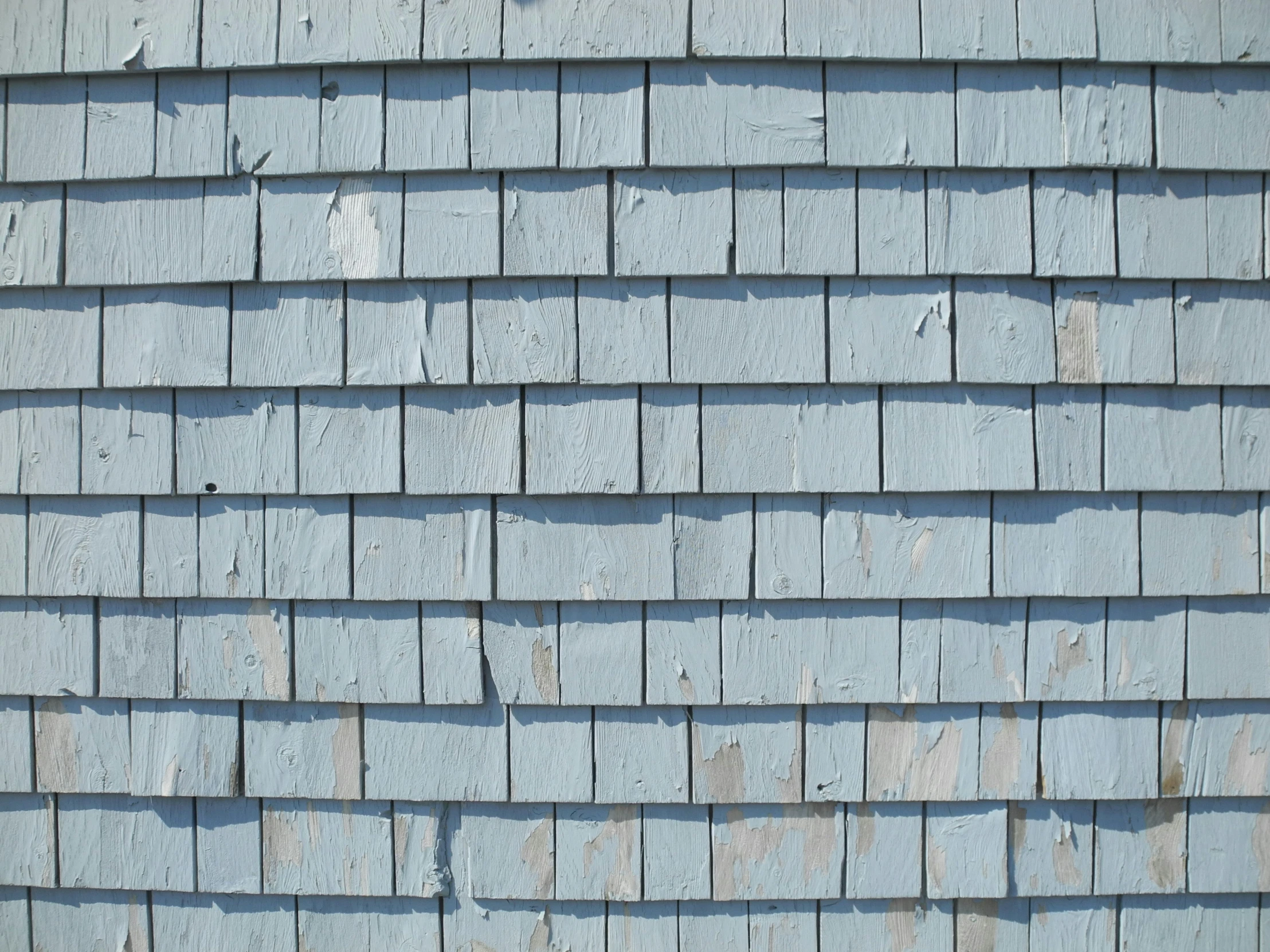 the side of a blue wooden shingled roof