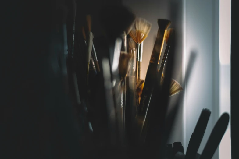 a view of the top of a small white vase filled with makeup brushes