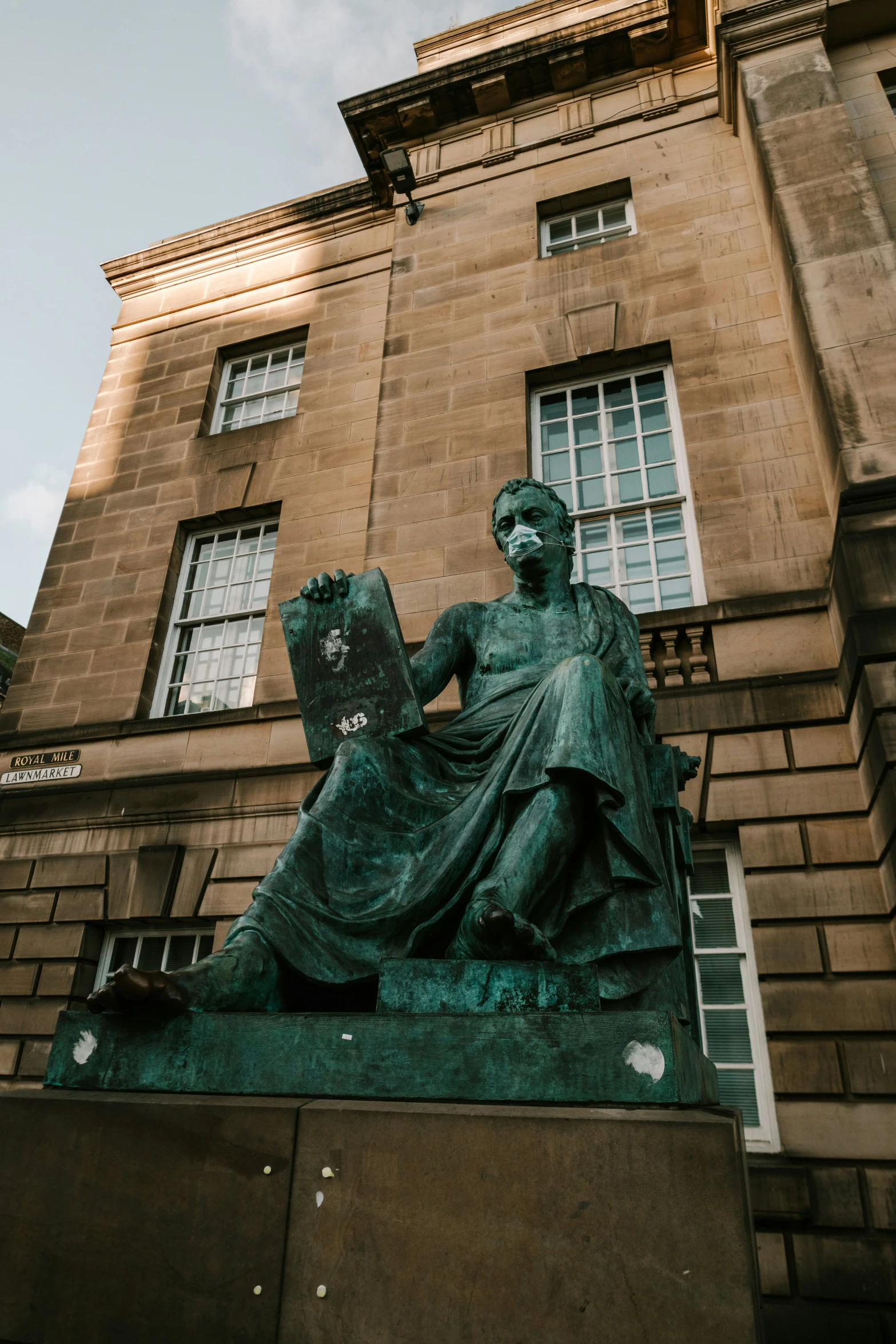 a statue of a woman holding a book on top of a box