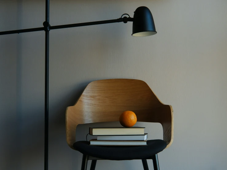 there is a book and an orange on the chair