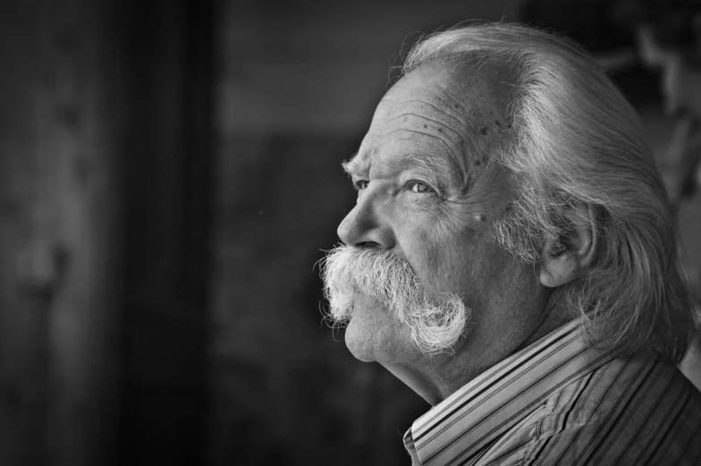 a man with white hair wearing a striped shirt