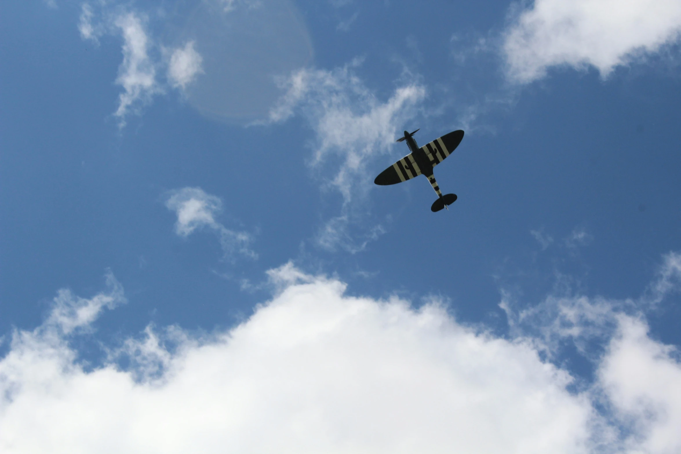 a small plane flies high in the sky