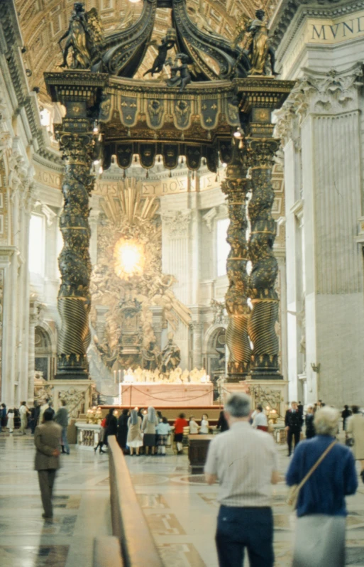 the people are standing inside of the large room