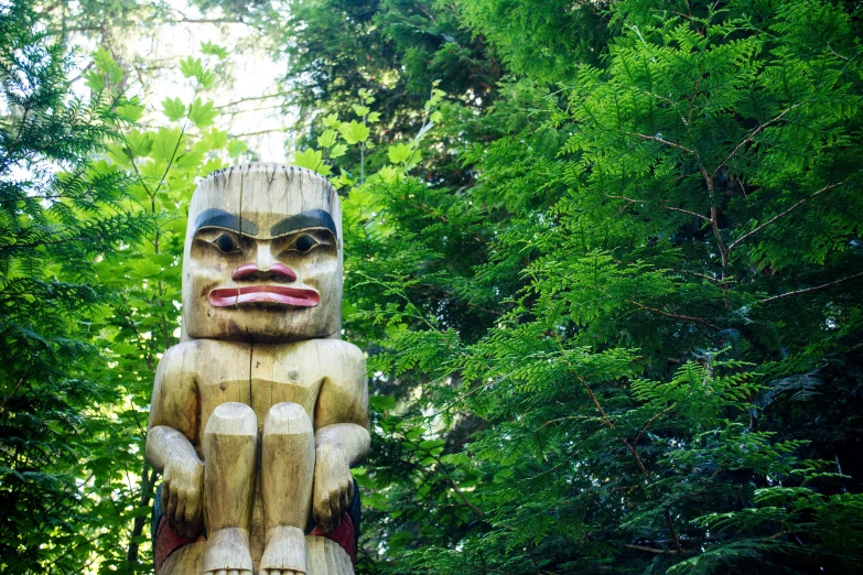 a large wooden statue of a person in the woods