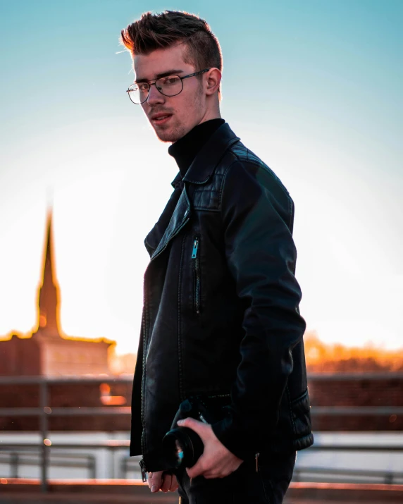 a young man is posing in the sun with his camera