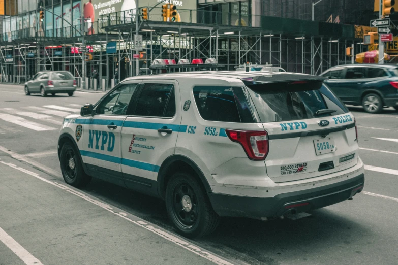 a police car on a street with many buildings