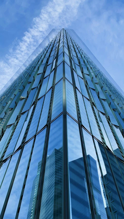 a tall building made of metal and glass against a blue sky