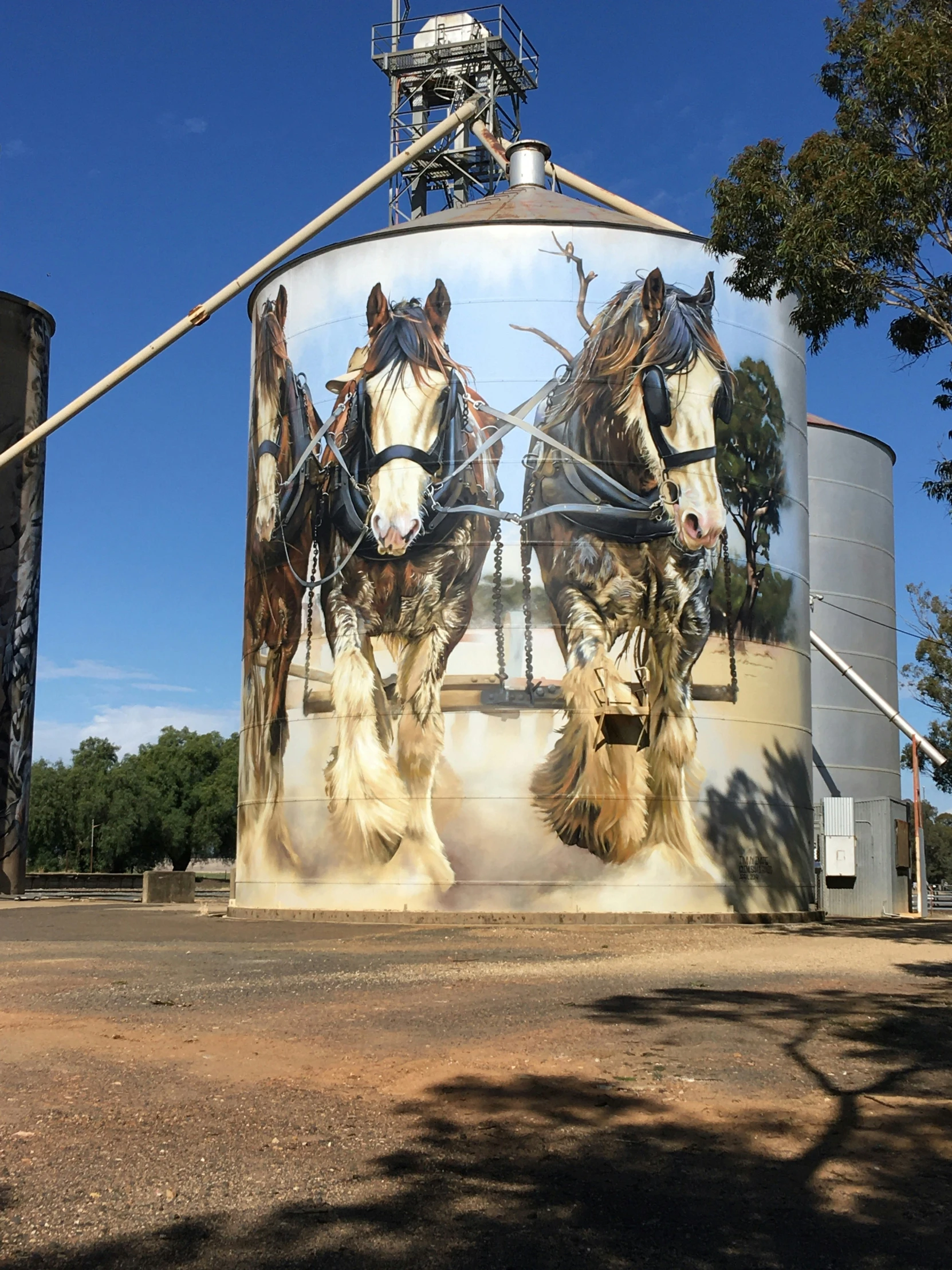 large mural of horse and man in harness attached to tank