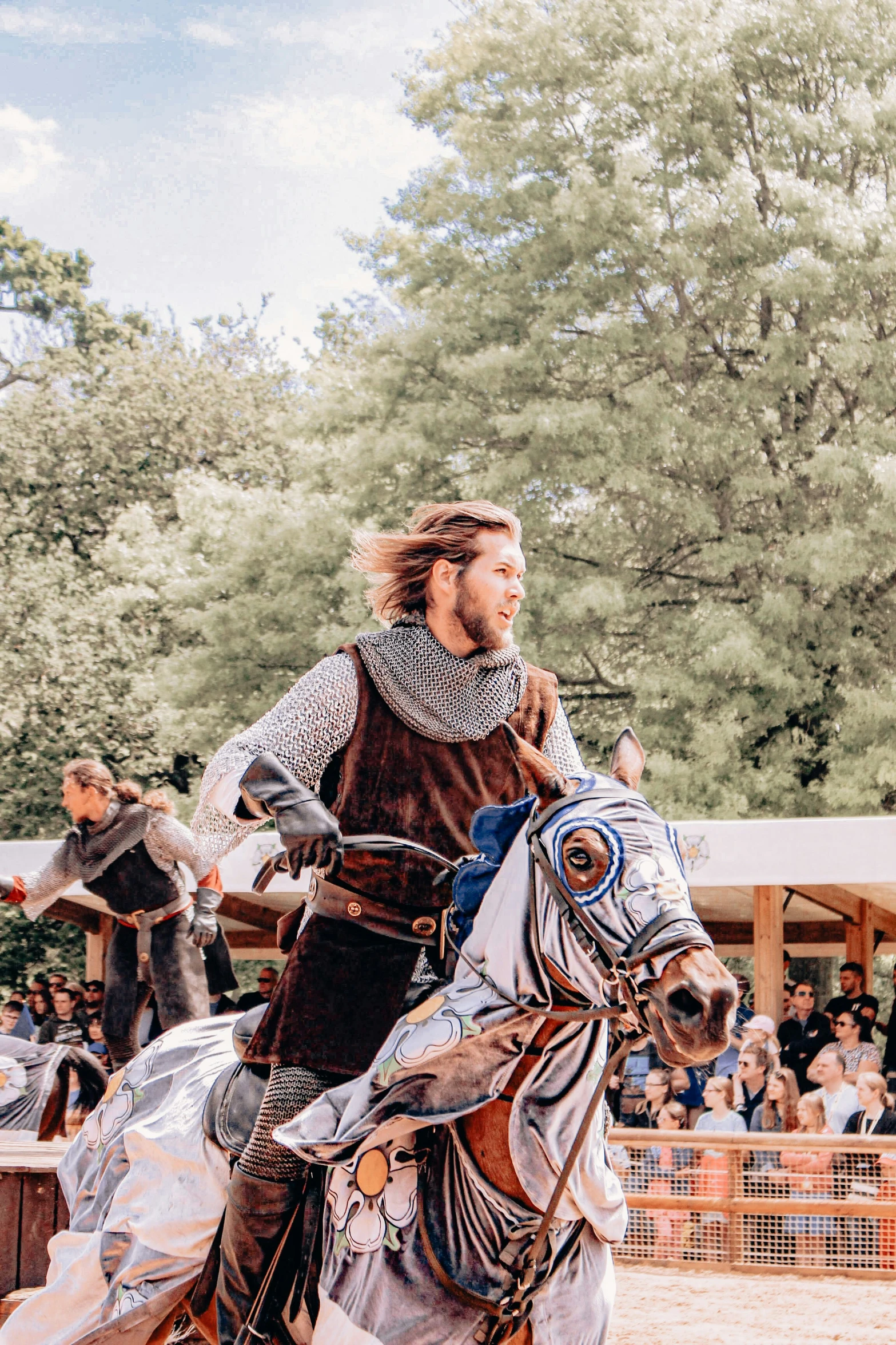 a man dressed in armor rides a horse through a crowd