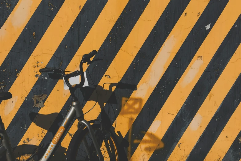 two bikes parked next to each other next to a yellow striped wall
