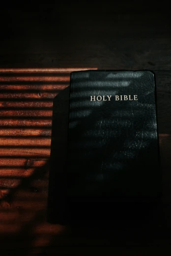 a bible on a wooden table and the word holy bible