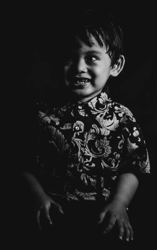 a  smiling at the camera in a dark room