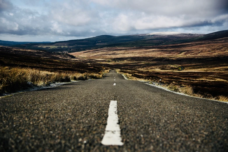 an empty and lonely road in the mountains