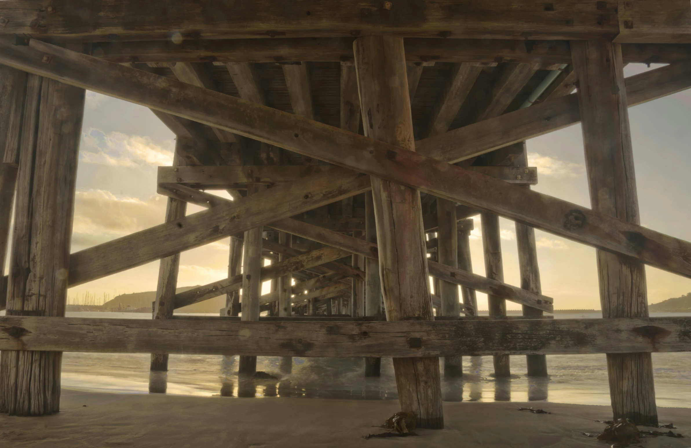 the underside view of a wooden bridge spanning water