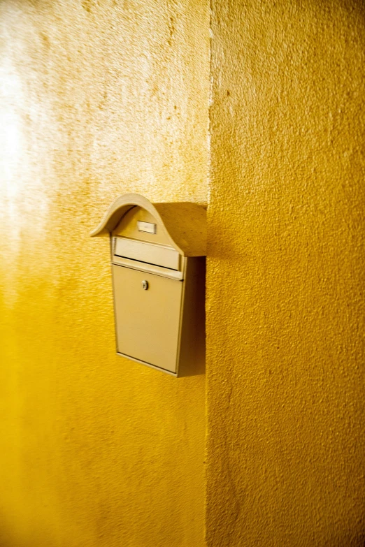 a post box attached to a yellow wall