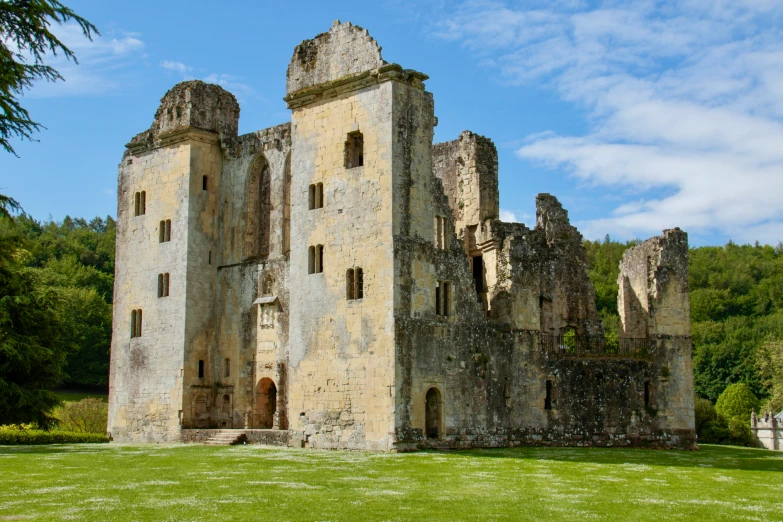 the remains of an ancient castle with green grass