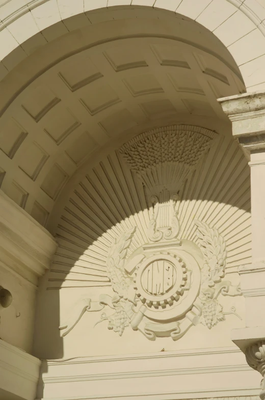 a building with an arch next to a statue and a clock