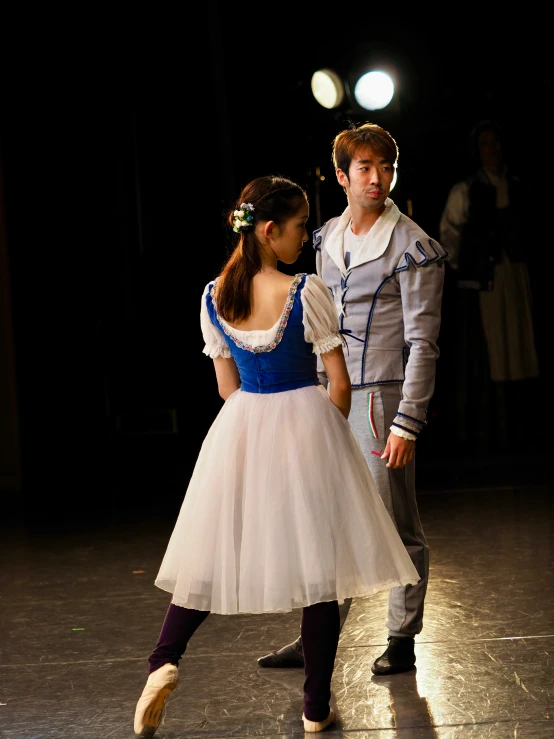 a man in a grey coat and a woman in a white dress