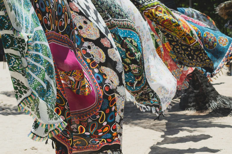 colorful fabrics drying outside on a beach