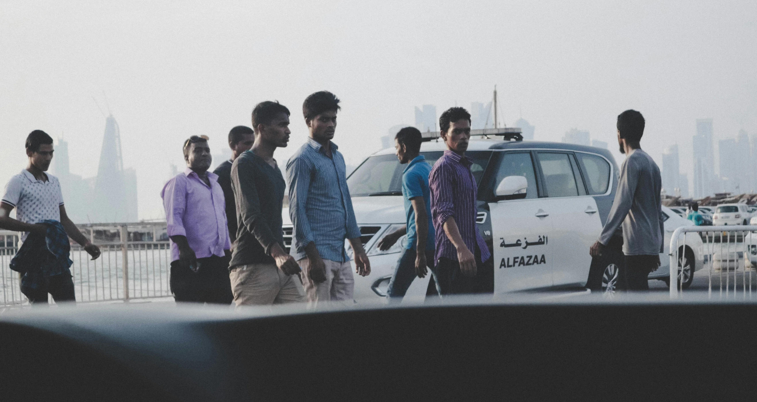 a group of men walking beside each other across a bridge