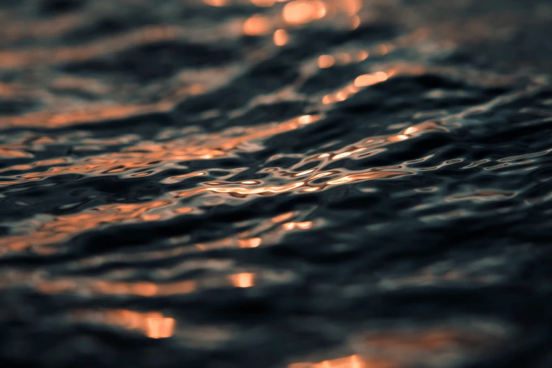 close up view of some water waves with sunset on the shore