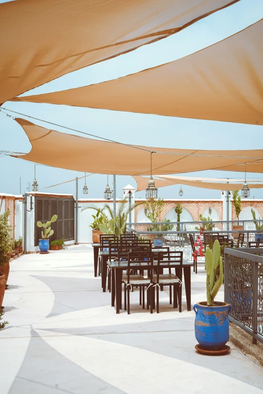 a cafe patio area with several tables, chairs and umbrellas