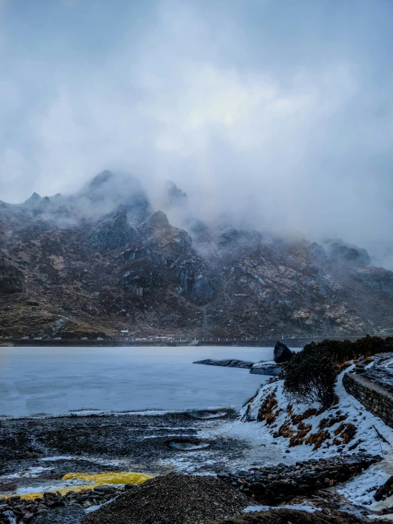 an old road along a body of water surrounded by snow