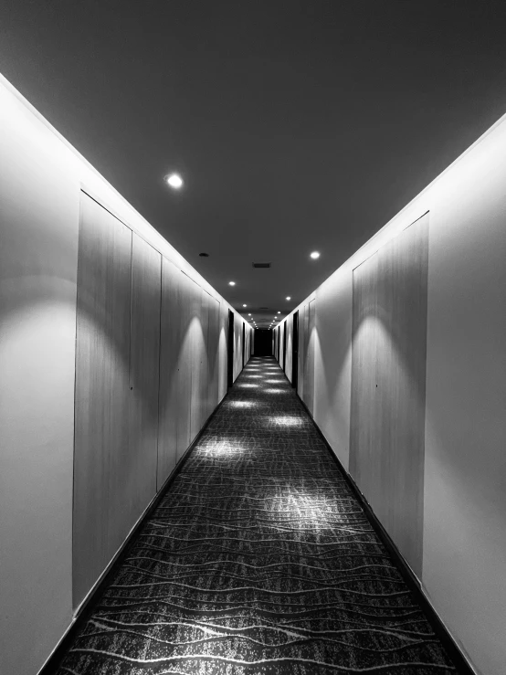 the long hallway has a row of closed cabinets