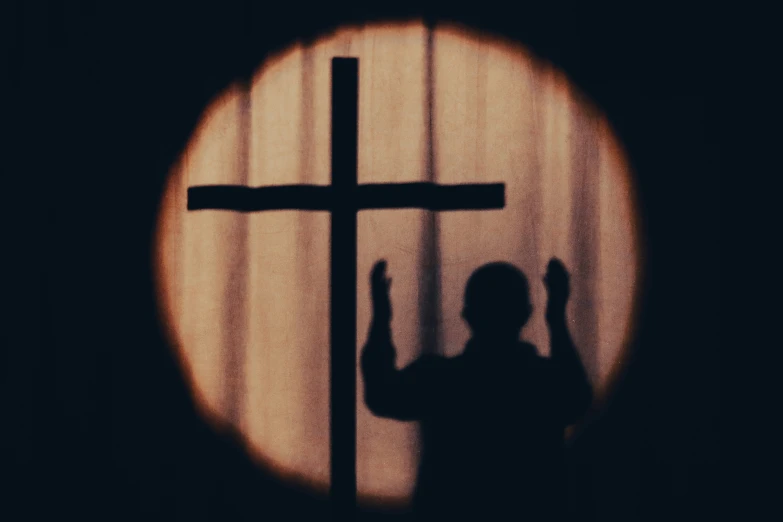 a woman is shown standing in front of a cross