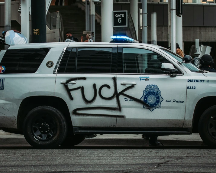 a police car with graffiti that reads ing