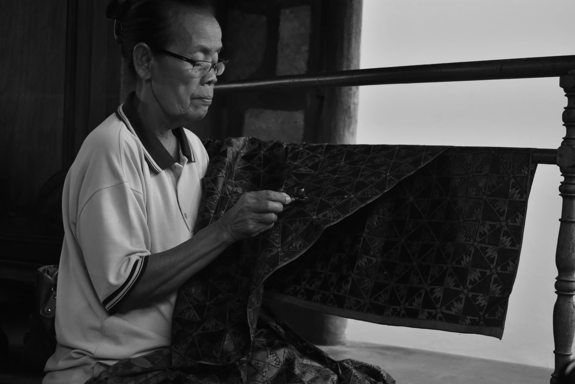 black and white image of an old man weaving