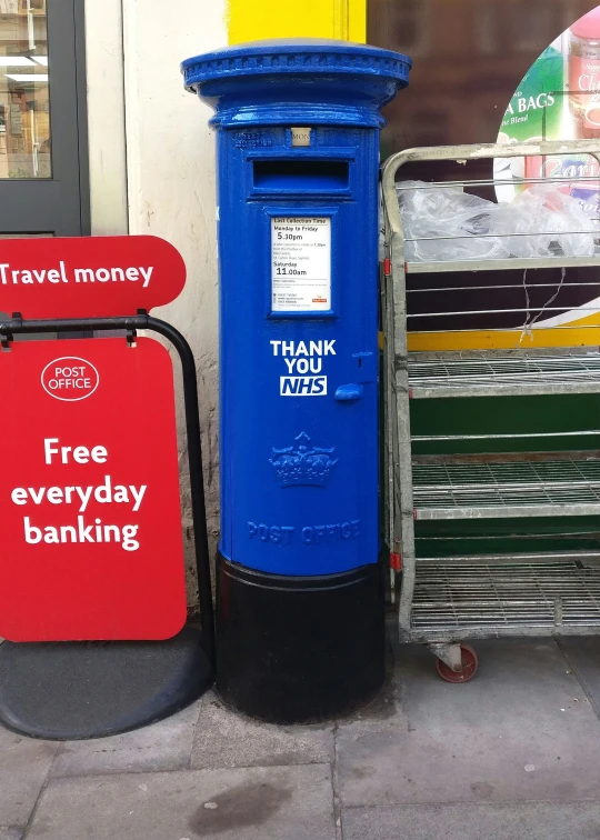 a blue free phone booth on the corner