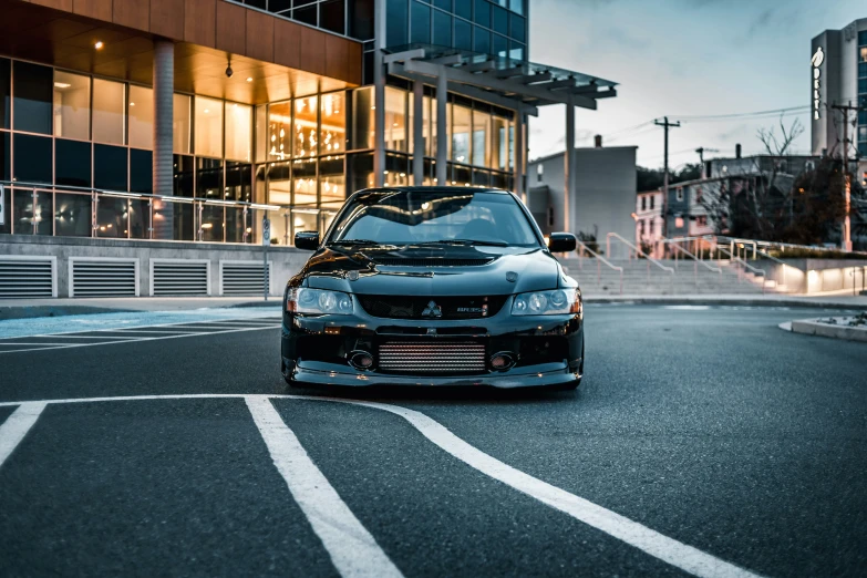 a black car sitting in front of a tall building