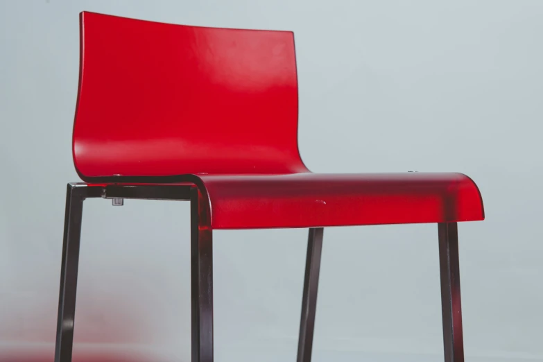 a red chair next to a white wall