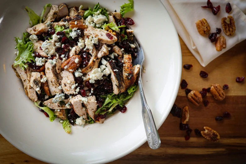 a salad is shown on a white plate with silverware