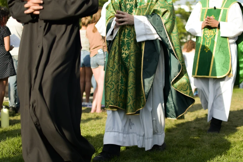 people in church gowns walking on grass