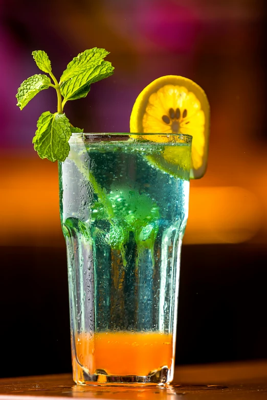 a yellow slice of lime sitting on top of a glass with a beverage