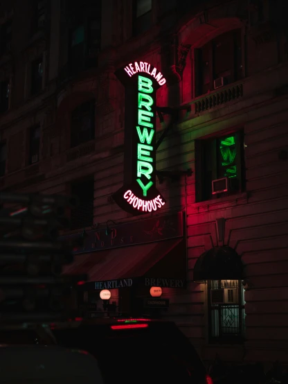 a green neon sign that is on the side of a building