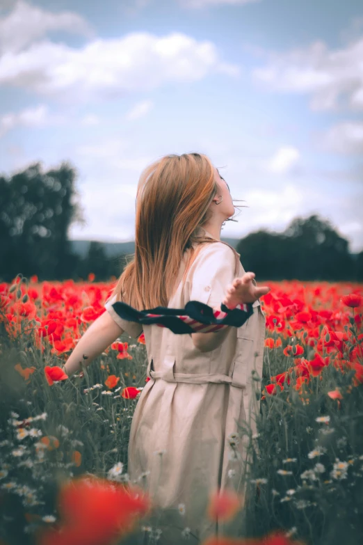 a girl with long hair standing in a field of flowers