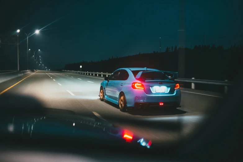 a car traveling at night on a road in the dark