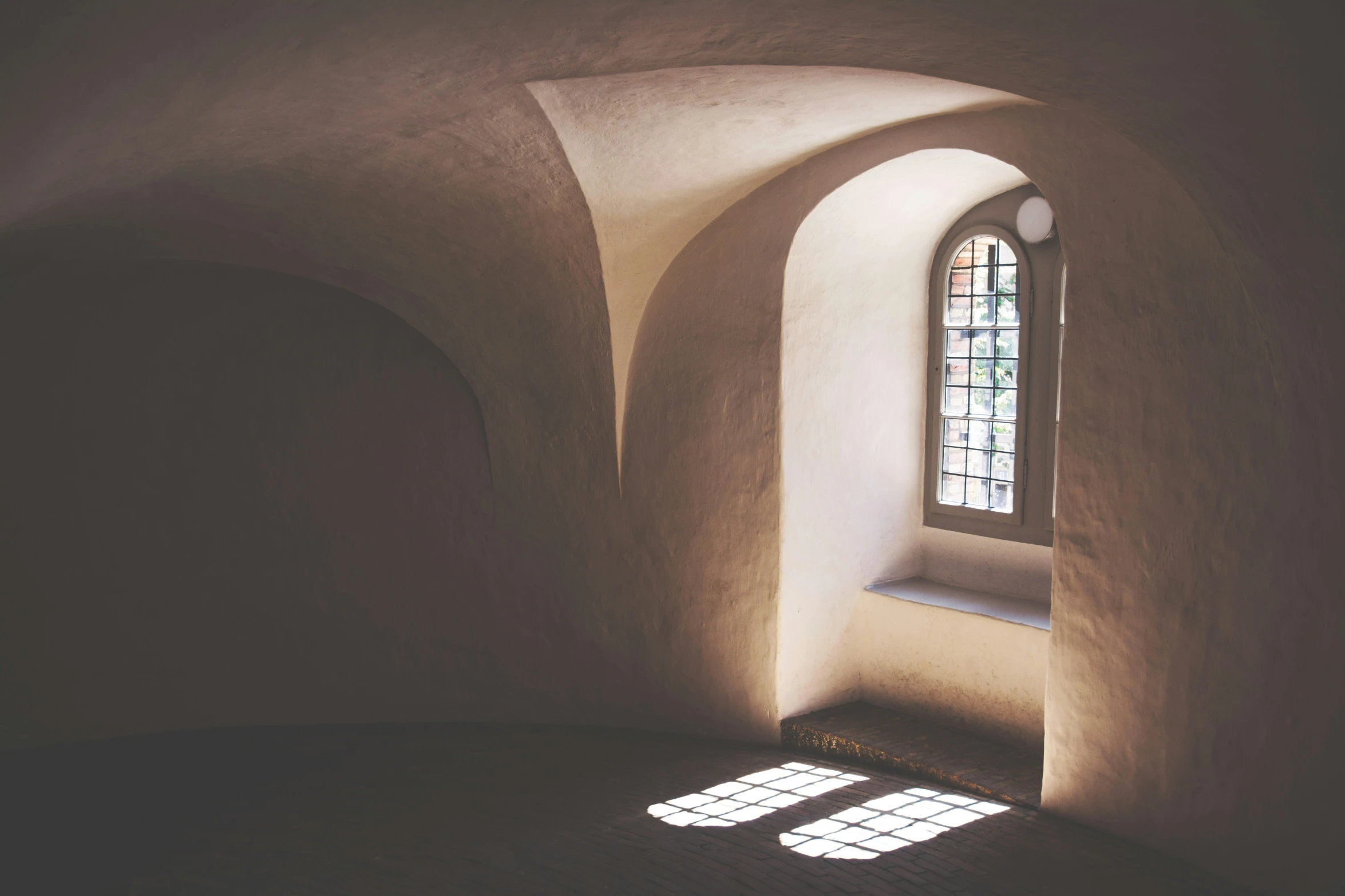 light coming in through an arch between two windows