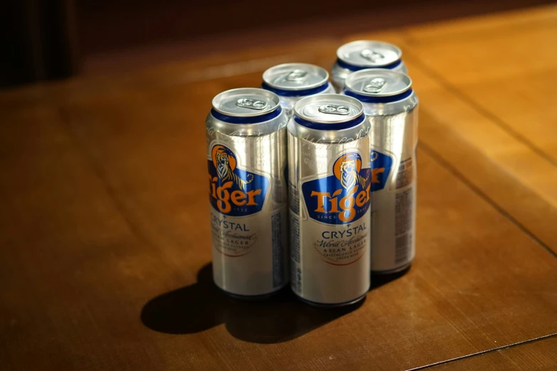 four can of beer sitting on a table with other cans
