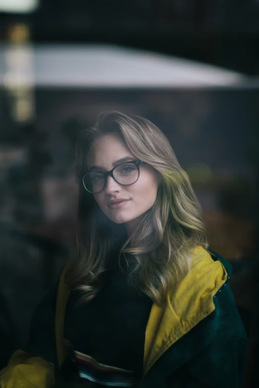 a girl in glasses wearing a black and yellow jacket