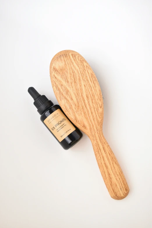 an essential blend for essential facial care and make up in a wooden spoon next to the bottle